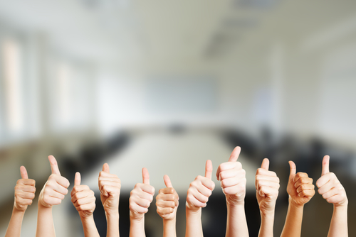 Row of thumbs up in office environment